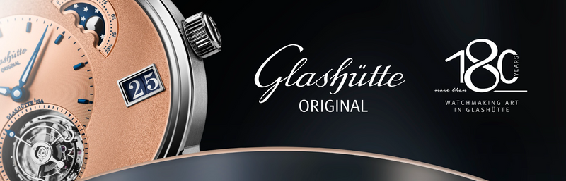 Close up of a copper toned Glashütte Original watch on a dark backdrop from an event banner.