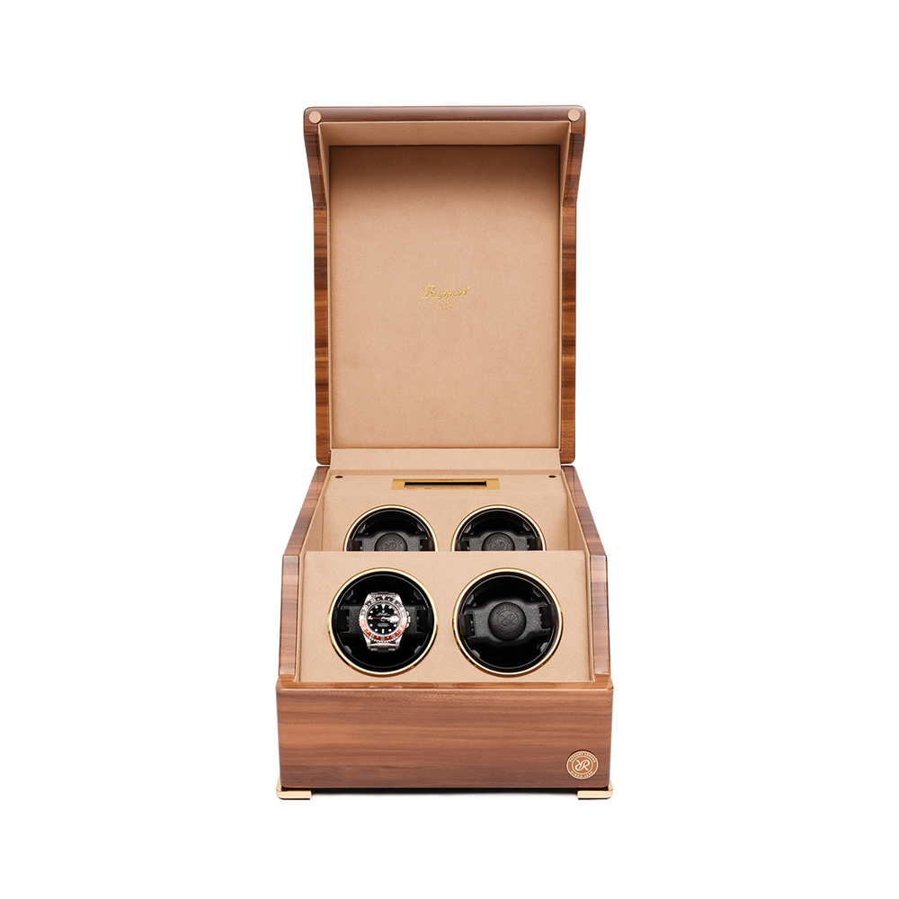 Perpetua Four Watch Winder in wood with lid open revealing four slots and a watch in the bottom-left slot