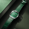 Steel square watch with natural malachite green dial and green leather strap.
