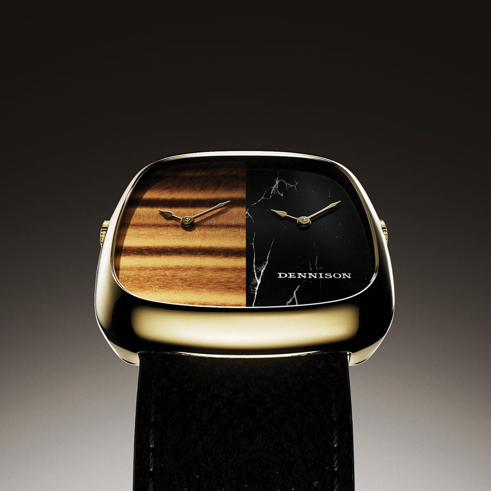 Close up of the gold toned ALD Dual Time dial split into tiger eye left and marble right with a leather strap