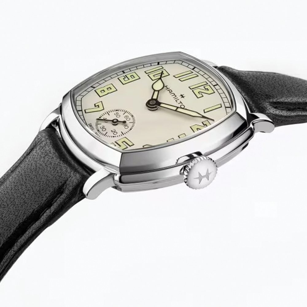 Close up side view of the cushion case watch with beige dial crown and black leather strap