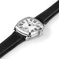 Close-up of cushion shaped watch with white dial Roman numerals on black leather strap.