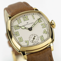 Hamilton American Classic Cushion Mechanical watch with gold tone case beige dial and brown leather strap.