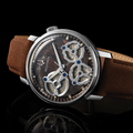 Angular close up of Spaceview Evolution 43.5mm skeleton watch on a brown leather strap against a dark background.