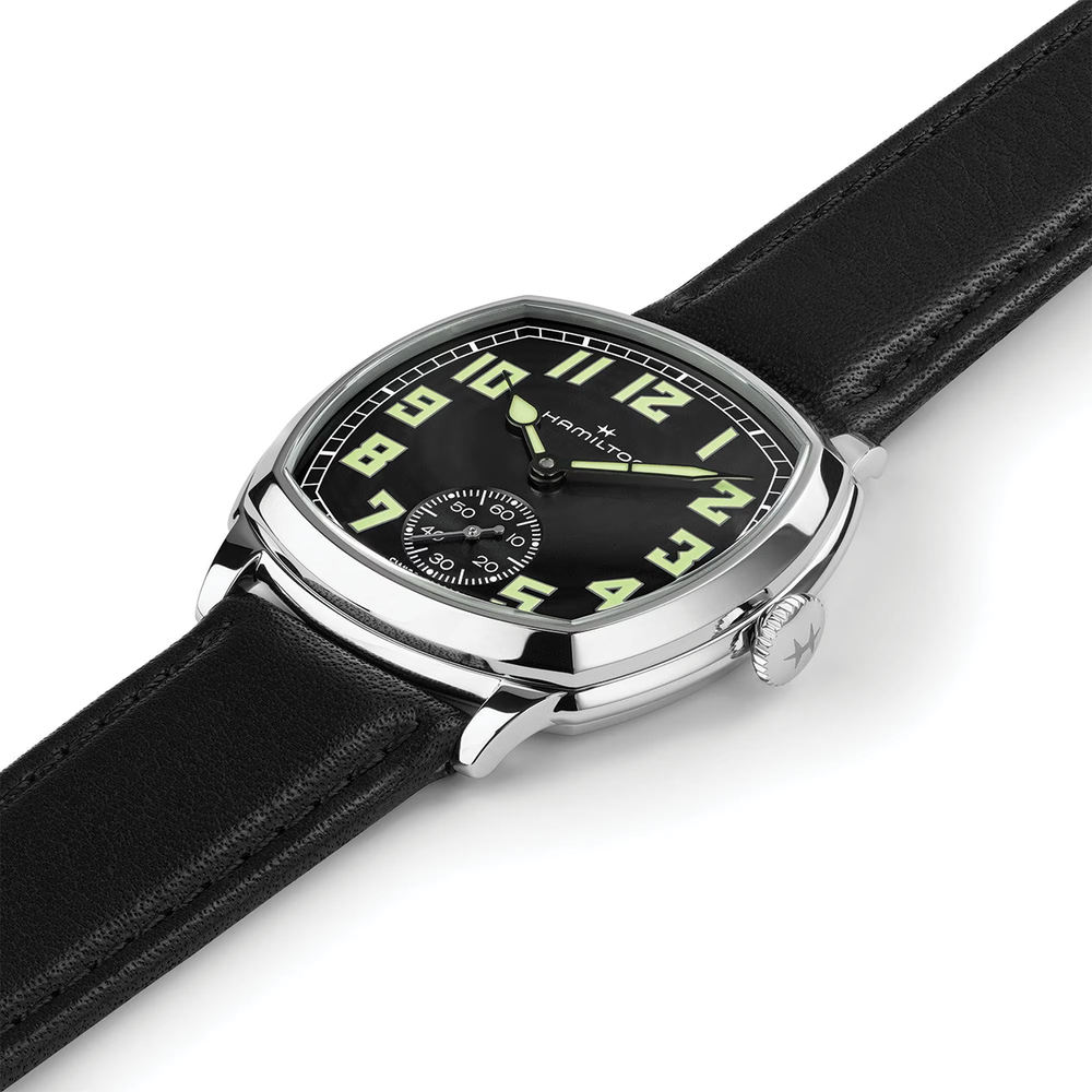 Close-up of the cushion case dial with luminous numerals and crown