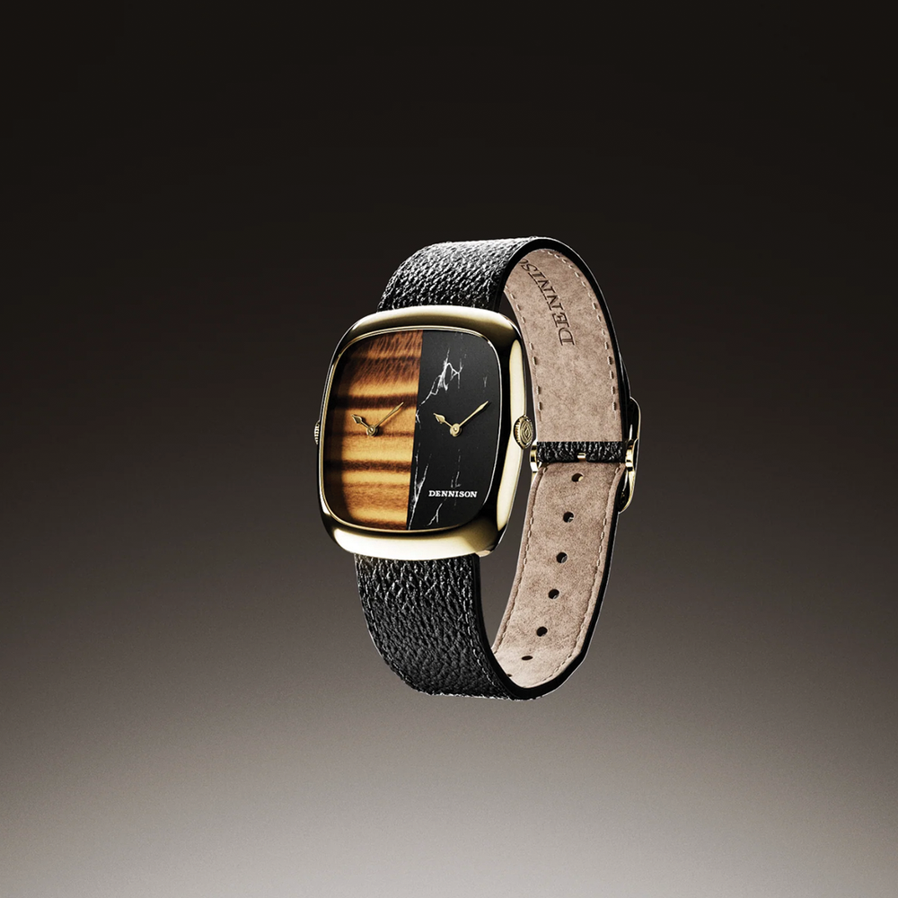 Dual time watch with gold square case featuring tiger eye wood and black marble dial halves on a textured black leather strap