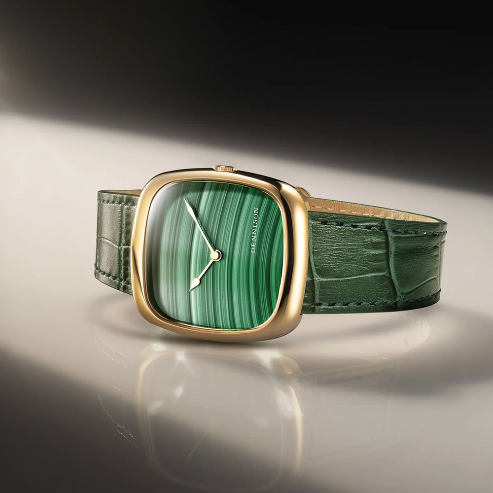 Side angle of a gold watch featuring a green malachite dial and green leather strap