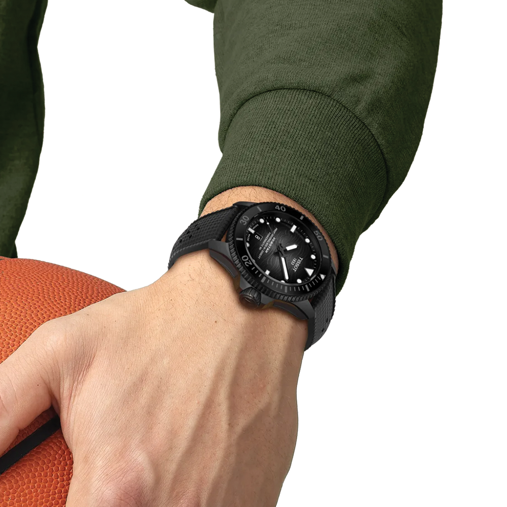 Tissot Seastar 2000 professional dive watch worn on the wrist with a black textured rubber strap and a green sleeve