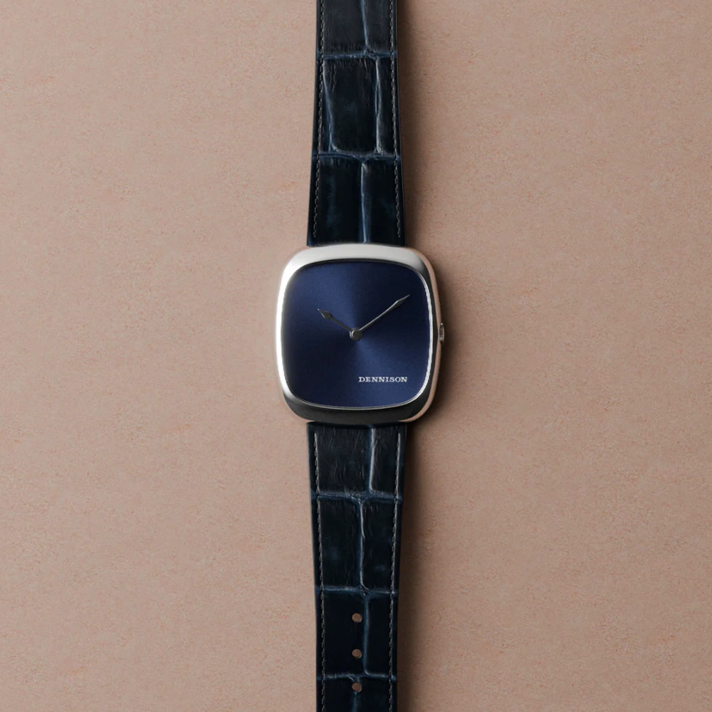 Close-up of blue sunray dial watch in steel with a dark blue leather strap.