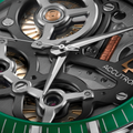Close-up of grey ElectroStatic DNA movement with copper gears and a green bezel