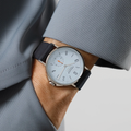 Wrist shot of Nomos Ahoi Neomatik Sky 36mm with light blue dial on a blue fabric strap.