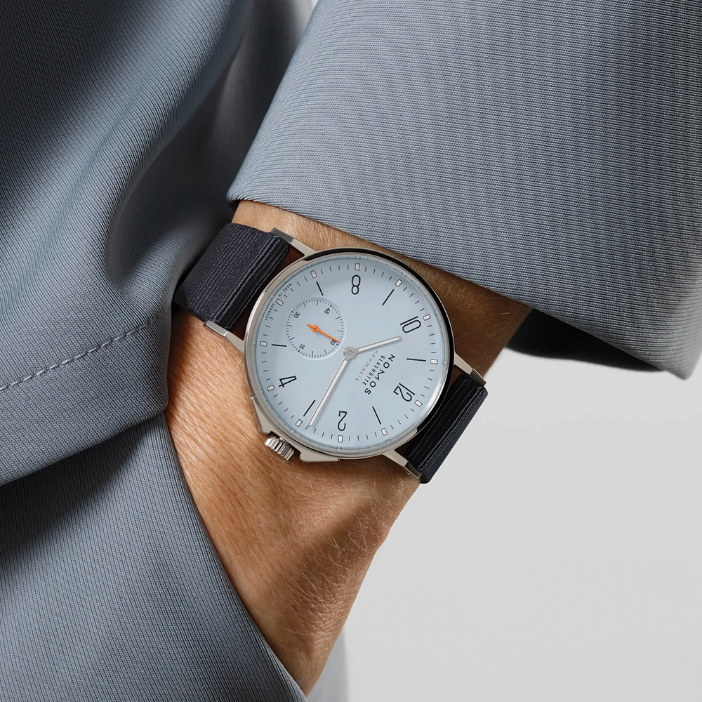 Wrist shot of Ahoi Neomatik Sky watch with a light blue dial steel case and dark blue fabric strap