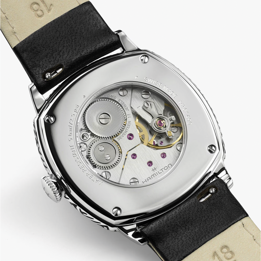 Case back view of the watch showing the exposed movement with gears and purple jewels