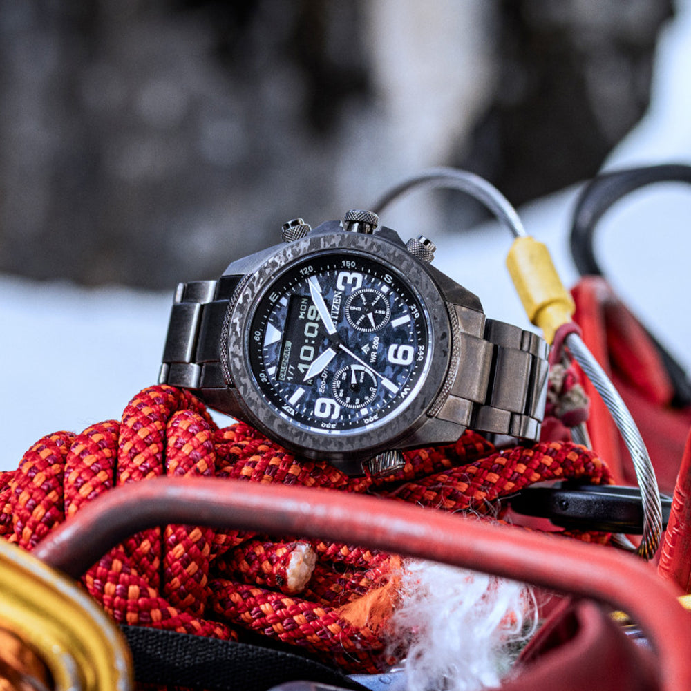 Rugged black watch with bold numerals rests on a red climbing rope outdoors